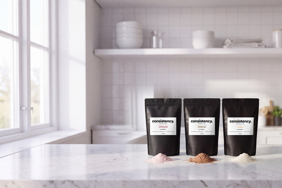 Consistency vassleprotein i jordgubb, choklad och vanilj, tre svarta påsar med pulverhögar på en ljus marmorbänk i köket