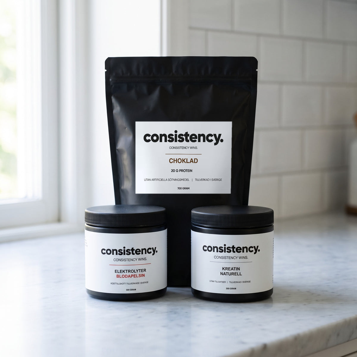 Consistency Complete: vassleprotein, kreatin och elektrolyter på köksbänk, protein choklad