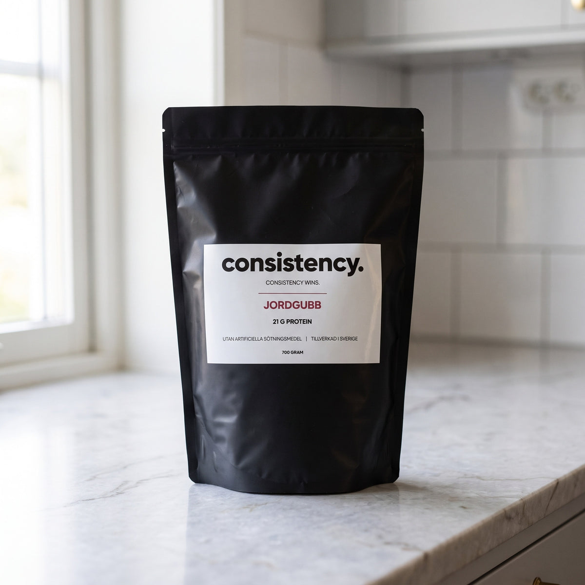 Consistency vassleprotein jordgubb, svart påse på köksbänk